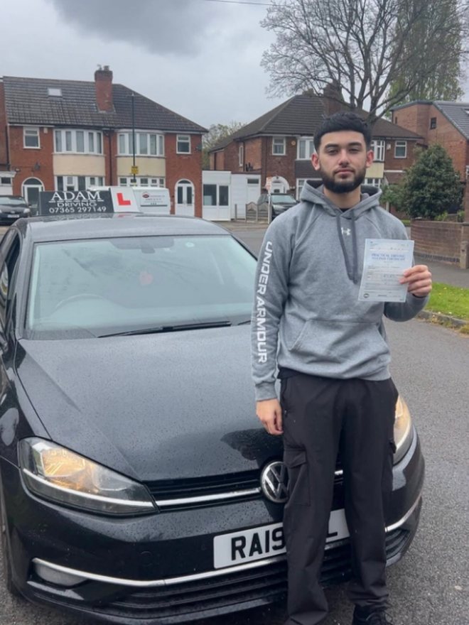 Student holding their driving test pass certificate beside the Adam Driving School car